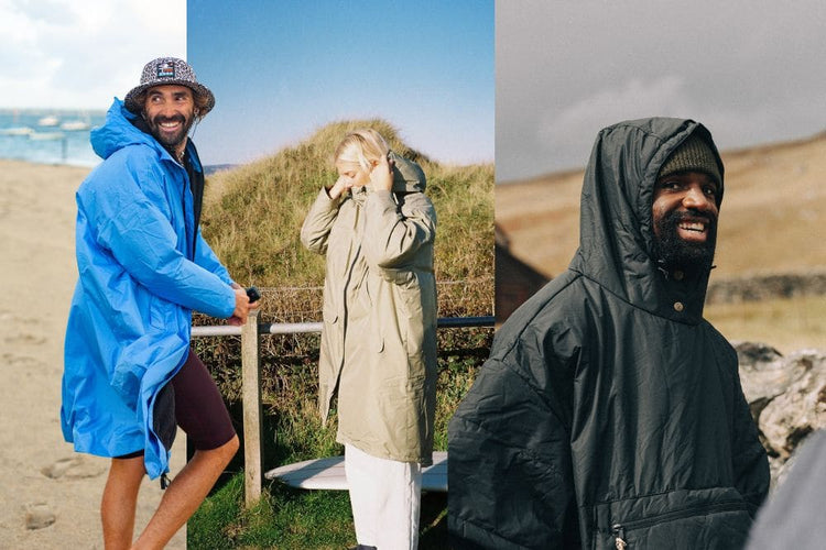 Three outdoor lifestyle shots showing people wearing hooded waterproof jackets in beach and dune settings. The left figure wears a bright blue hooded jacket, the center figure wears a light olive-beige hooded jacket, and the right figure wears a dark charcoal hooded jacket. Allweather Coat, ChangeRobe,Poncho VOITED